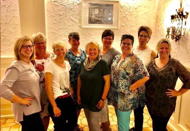 Gruppenfoto von neun Frauen in einem Gastraum