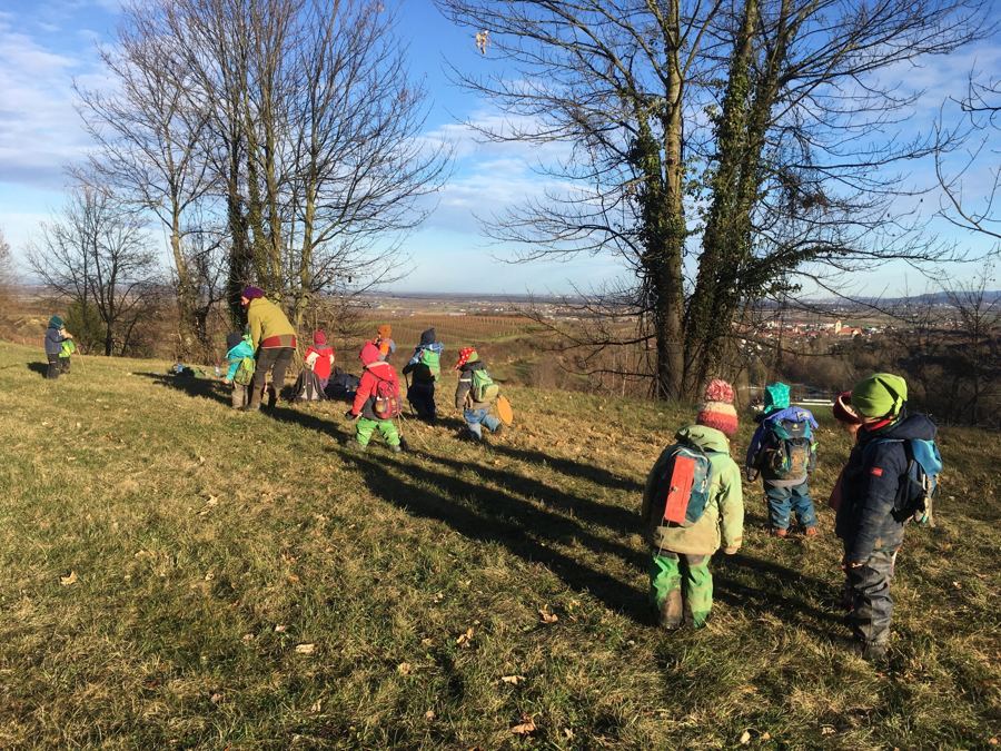 Kindergruppe mit Rucksäcken auf einer Wiese mit Blick über den Kaiserstuhl