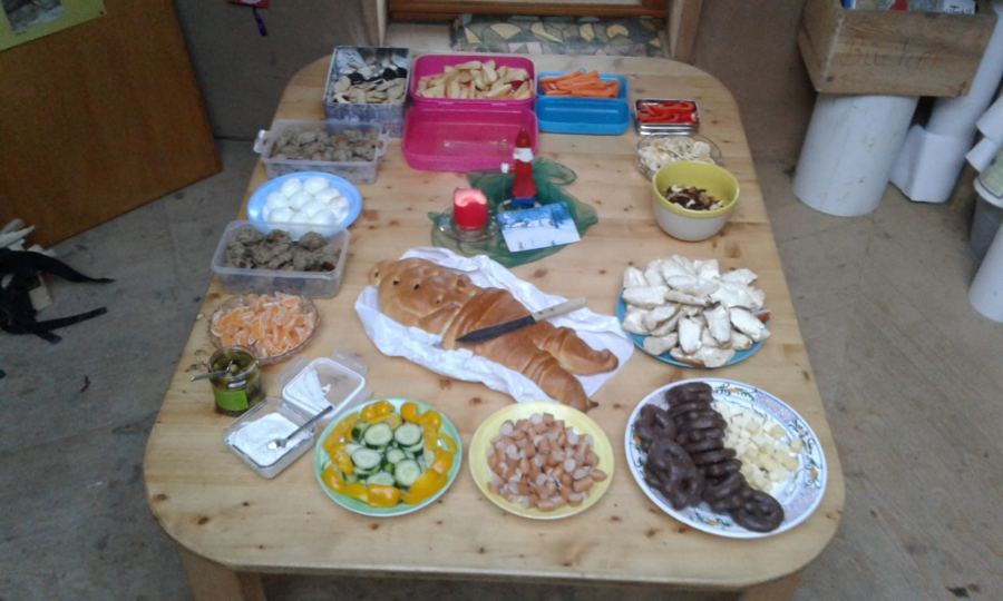 Gedeckter Tisch mit Hefezopf, Obst, Gemüse und kleinen Snacks für ein Fest